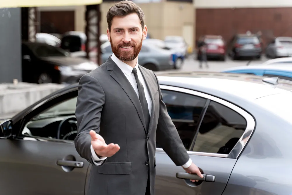 A chauffeur standing beside a luxury vehicle